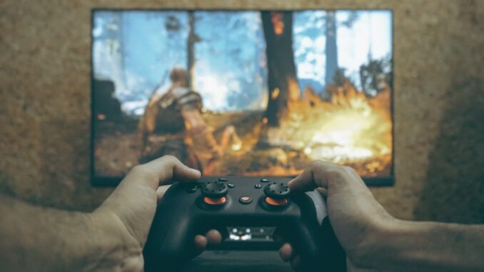 Hands holding a game controller playing a video game.
