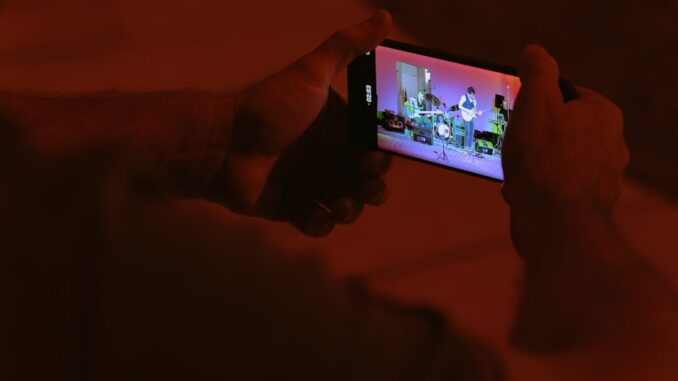 A person taking a picture with a cell phone