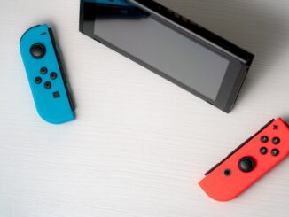 blue nintendo switch beside black tablet computer