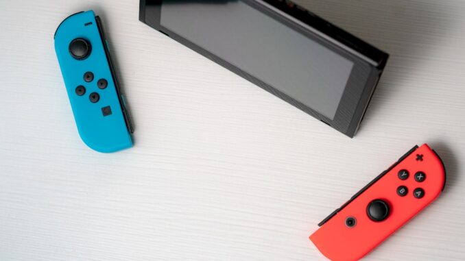 blue nintendo switch beside black tablet computer