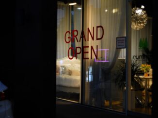 Grand open sign in a lit storefront window