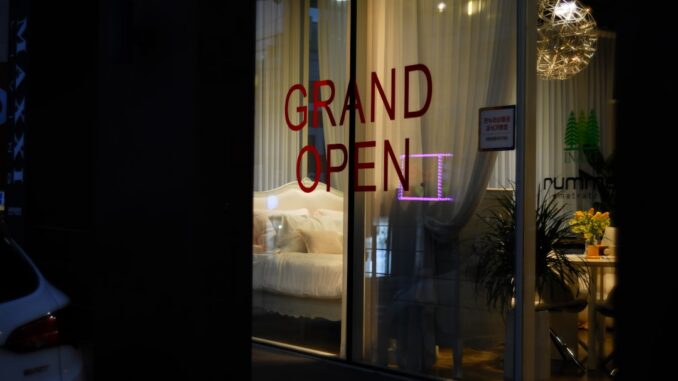 Grand open sign in a lit storefront window