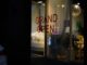 Grand open sign in a lit storefront window