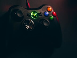 black Xbox 360 corded game controller on black surface