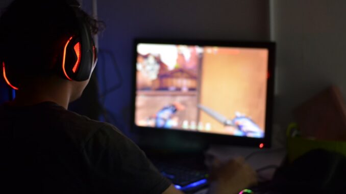 A man wearing headphones playing a video game