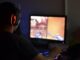 A man wearing headphones playing a video game