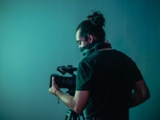 woman in black t-shirt holding black dslr camera