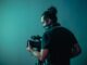 woman in black t-shirt holding black dslr camera