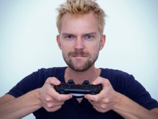 man in blue long sleeve shirt holding black semi automatic pistol