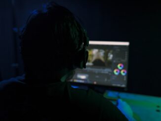 a man sitting in front of a computer monitor
