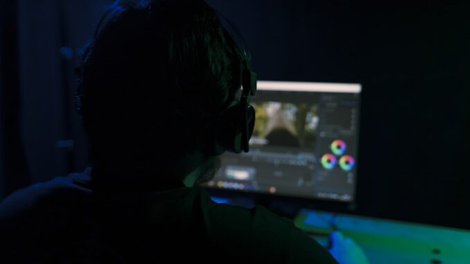 a man sitting in front of a computer monitor