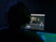 a man sitting in front of a computer monitor