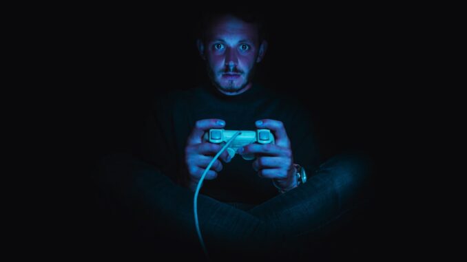 man holding corded game controller