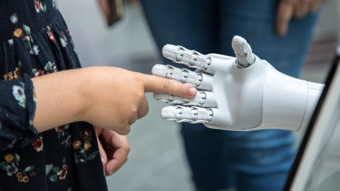a person holding a robotic hand in front of a mirror