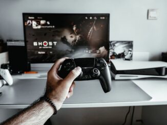 a person holding a video game controller in front of a tv