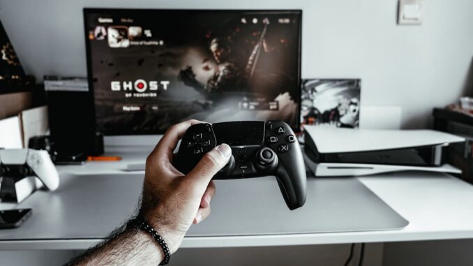 a person holding a video game controller in front of a tv