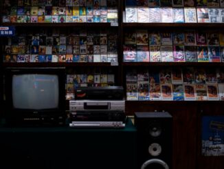 a television sitting on top of a table in front of a book shelf